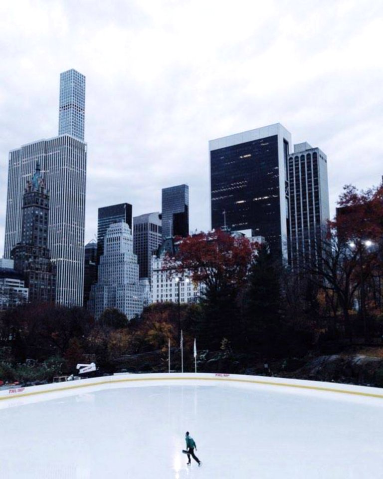 Lone Person Ice Skating Under Heavy Clouds