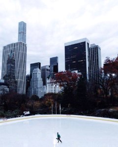 Lone Person Ice Skating Under Heavy Clouds