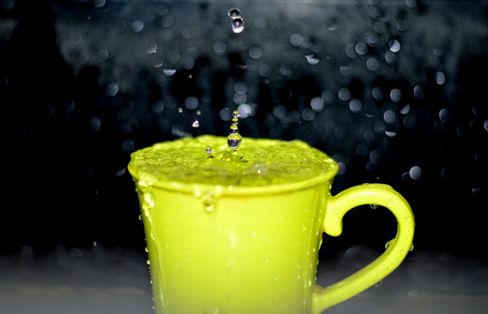 Yellow Ceramic Mug With Water Droplets In Time Lapse Photography