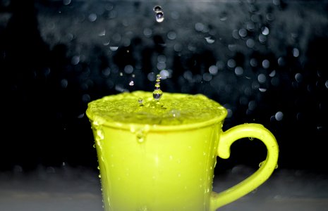 Yellow Ceramic Mug With Water Droplets In Time Lapse Photography
