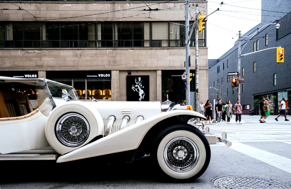White Vehicle Near Gray Lamp Post And Brown Building Structure