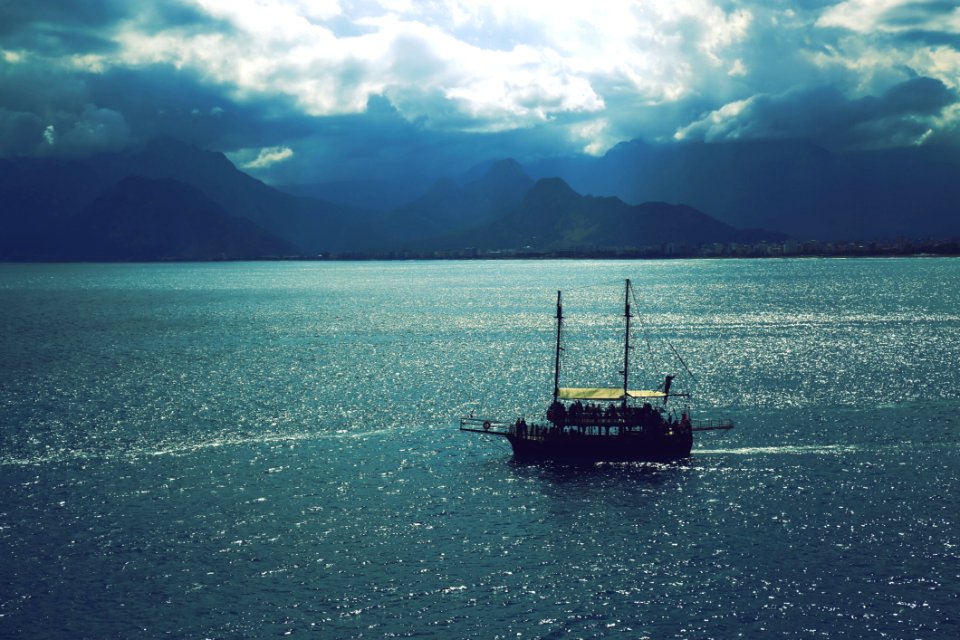 Sailboat Sailing Near Mountains Under Cloudy Sky