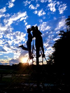 Silhouette Photo Of Man And Woman Kissing Under White And Blue Sky During Sunset photo