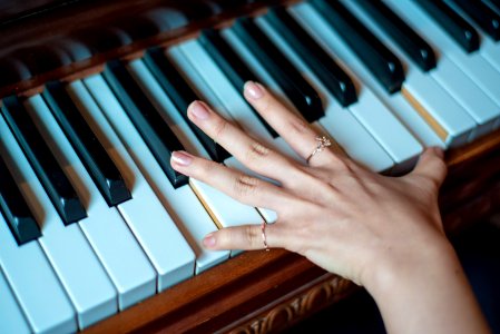 Brown Wooden Piano Used By A Person Using 2 Fingers photo