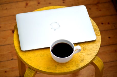 Silver Macbook Beside White Cup