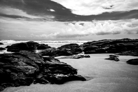Grayscale Photography Of Rocks On Seashore During Daytime photo