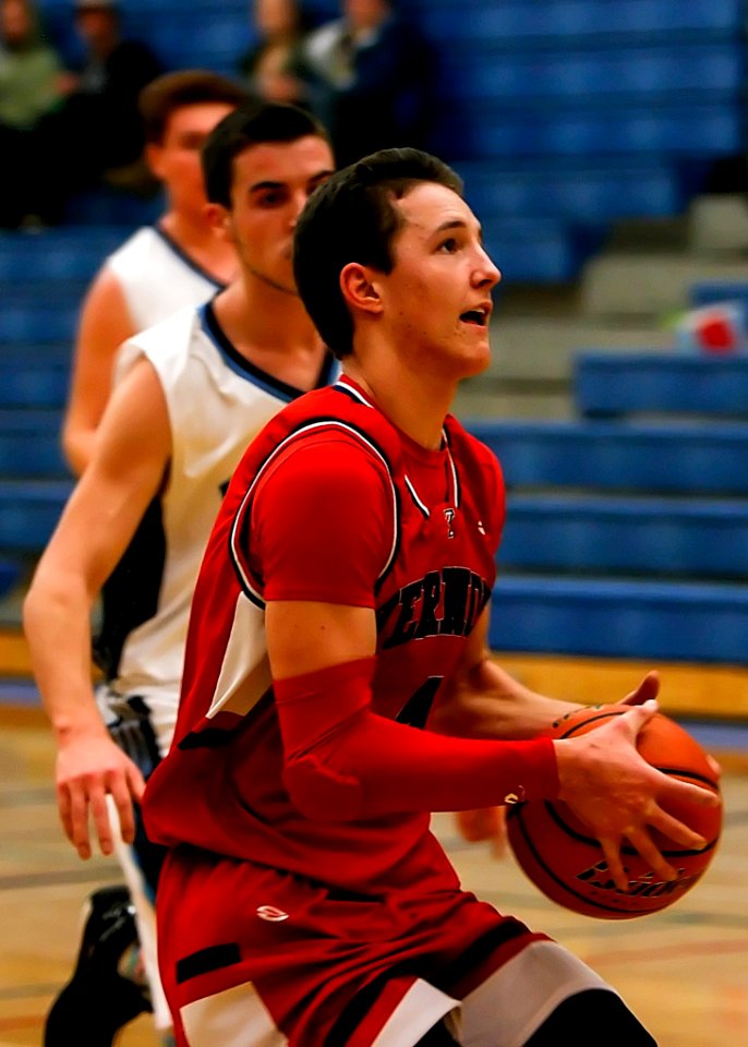 A Man Wearing Red Jersey Carrying An Orange Basketball
