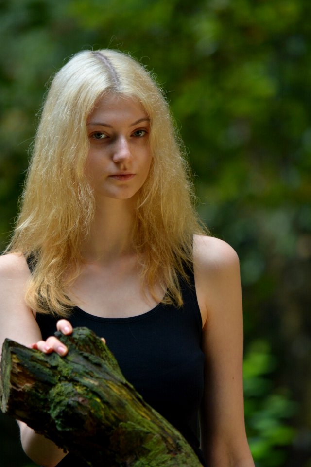 Woman In Black Tank Top While Her Right Hand Is Holding A Tree Branch