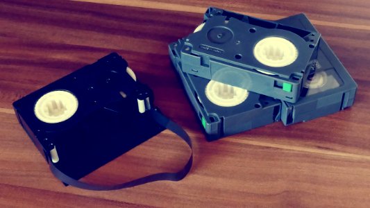 Betamax Tapes On Top Of Brown Wooden Surface
