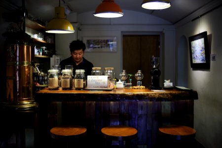 Man On Black Polo Shirt Is Standing Infront Of Bar Counter