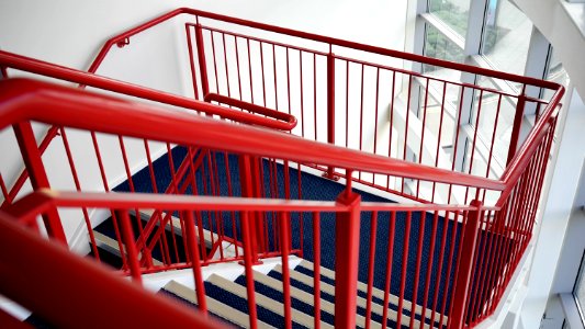 Blue And White Wooden Stairs With Red Metal Handrails photo