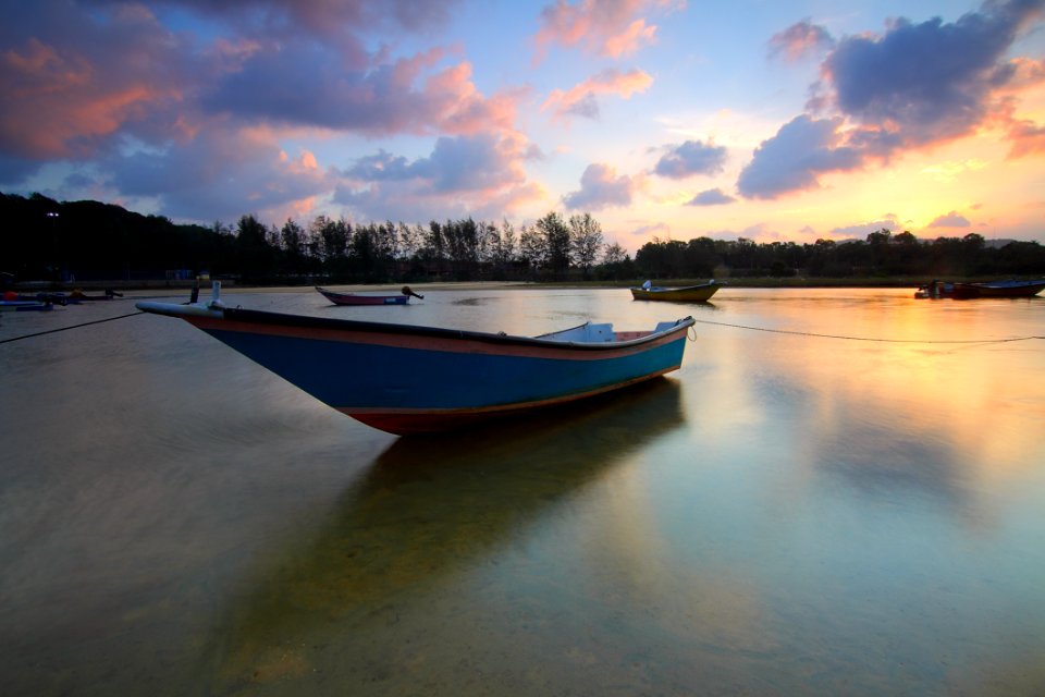 Wooden Boat In Water At Sunset