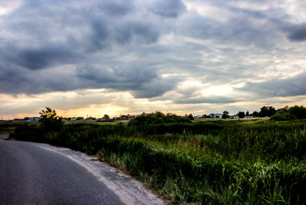 Clouds Over Grass Next To Road
