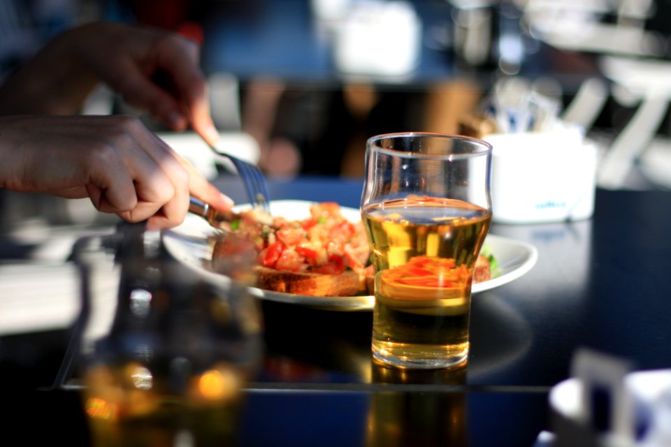 Pilsner Glass With Beer Beside White Plate