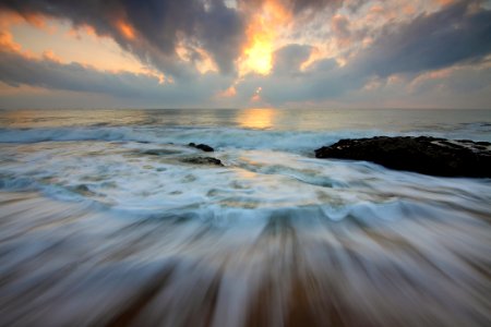 Time Lapse Photo Of Water Current And Brown Rock Under White And Yellow Cloudy Sky photo