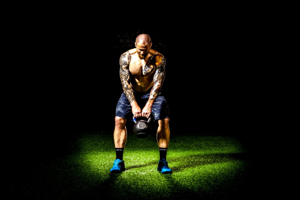 Man In Blue Shorts Carrying Brown Exercise Equipments