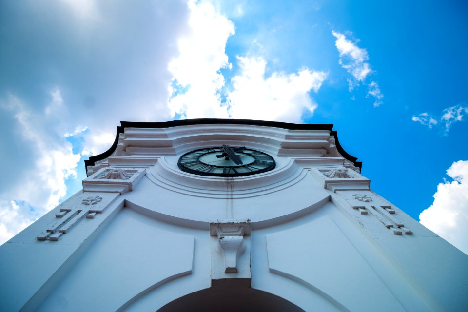 White Concrete Building With Clock Under Blue White Sky