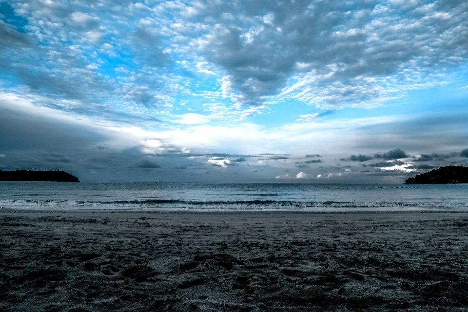 Gray Sand On Sea Shore Under Cloudy Sky During Daytime photo