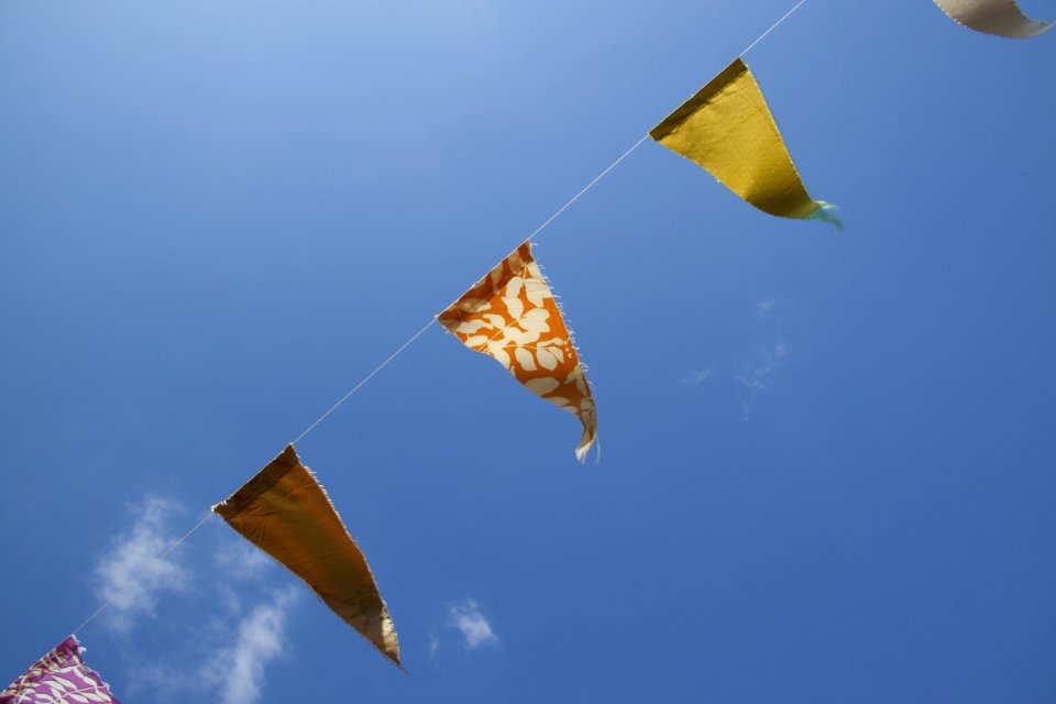Orange Yellow And Red Flaglets Under Blue White Sky During Daytime