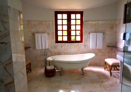 White Bathtub On White Tile Bathroom Near Brown Framed Clear Glass Window