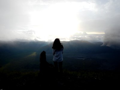Woman Staing At The Edge Of The Mountain Facing The Sun