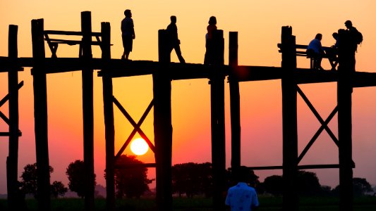 People Standing On A Bridge During Sunset
