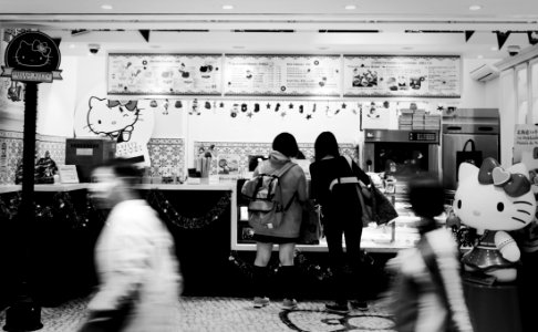 2 Women Standing Infront Hello Kitty Themed Store In Greyscale Photography photo