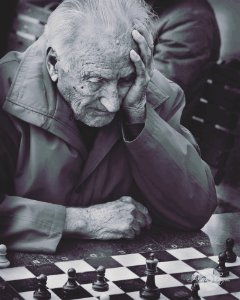 Grayscale Photo Of Man Playing Chess photo