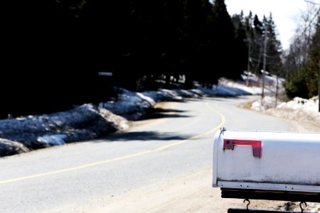 White Metal Mailbox Near Grey Asphalt Road At Day Time