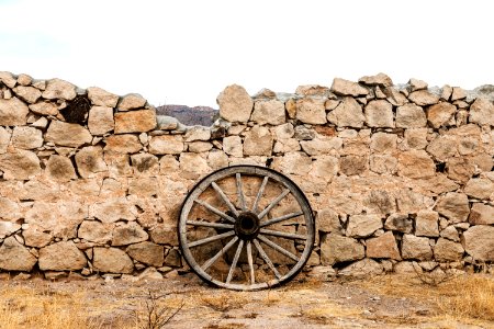 Wagon wheel against a stone fence at Hueco Tanks State Park, northwest of El Paso, USA. Original image from Carol M. Highsmith’s America, Library of Congress collection. photo