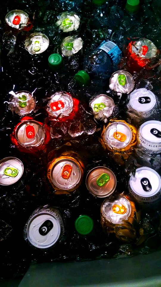 Drinking Cans And Bottle On Water With Ice Cubes