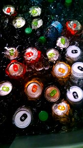 Drinking Cans And Bottle On Water With Ice Cubes