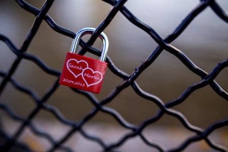 Red And Stainless Steel 2 Hearts Padlock On Black Cyclone Fence During Daytime photo