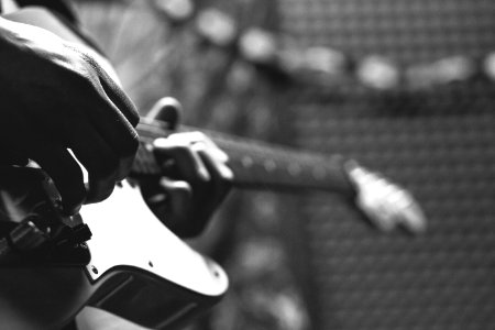 Grayscale Photo Of Person Holding Electric Guitar photo