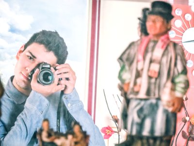 Man In Blue Denim Jacket Using Black Dslr Camera photo