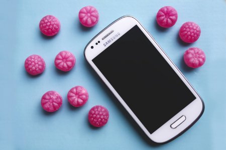 Pink Candies And White Smartphone photo
