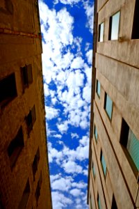 Low Angle Photography Of Brown Concrete Building Under White Cloudy Blue Sky At Daytime photo