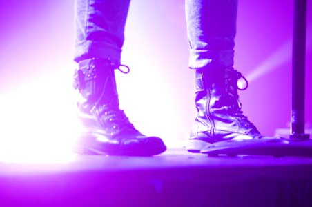 Person Wearing Lace Up Boots Standing On Stage photo
