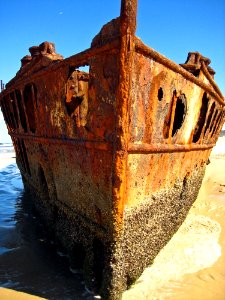 Brown Metal Shipwreck On Seashore During Daytime photo