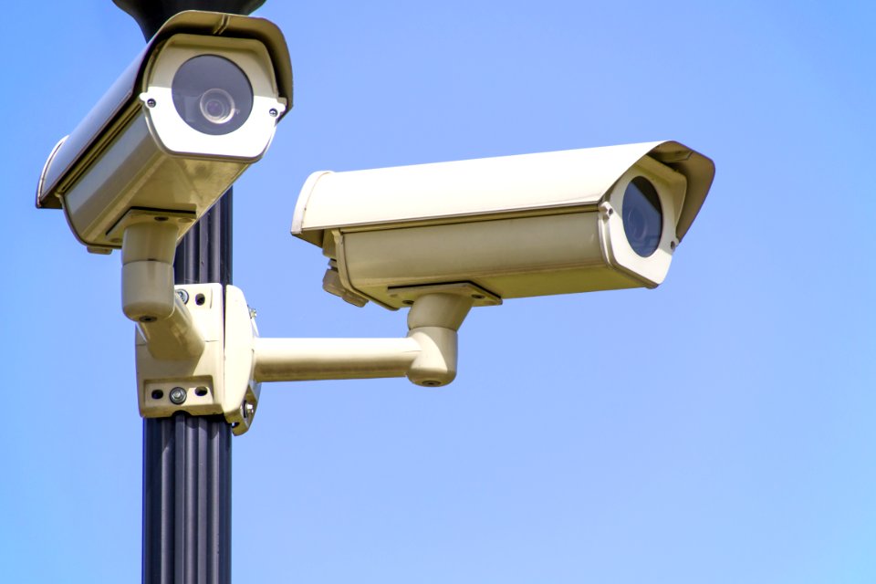 White 2 Cctv Camera Mounted On Black Post Under Clear Blue Sky