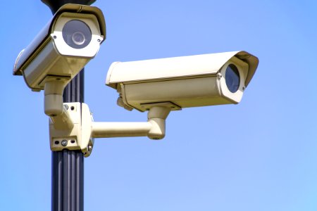 White 2 Cctv Camera Mounted On Black Post Under Clear Blue Sky photo