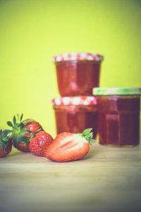 Strawberry Near Red Jar On Wooden Surface photo