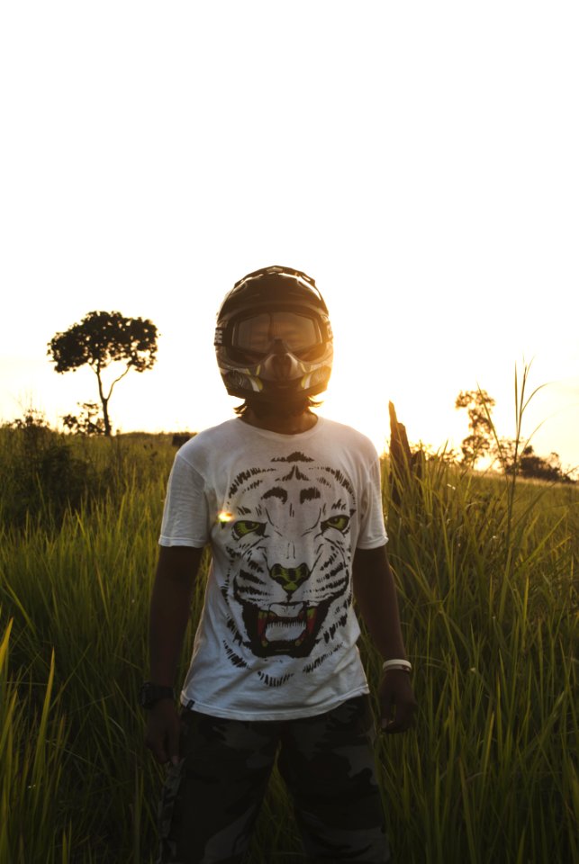 Man In Black Full Face Helmet Standing On Green Grass During Daytime photo