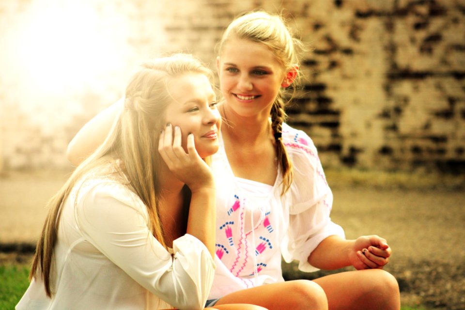 Two Women Sitting Down Smiling