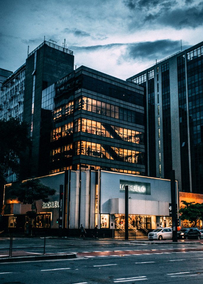 Black High Rise Building Under Grey And White Sky During Night Time