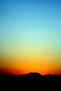 Silhouette Of Mountain Under Orange And Blue Sky During Sunset photo