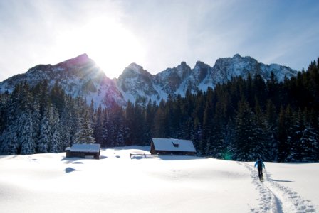 Man Walking Towards Brown Housen In A Snow Place photo