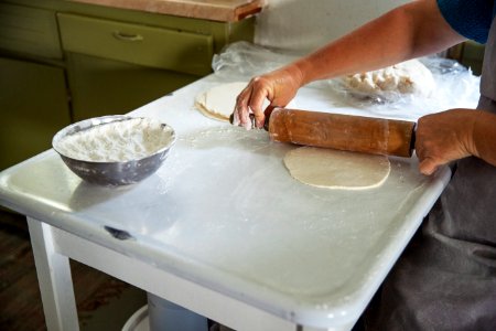 An Amish woman rolls dough to make small fried pies inside the farmhouse at Yoder's Amish Home. Original image from Carol M. Highsmith’s America, Library of Congress collection. photo