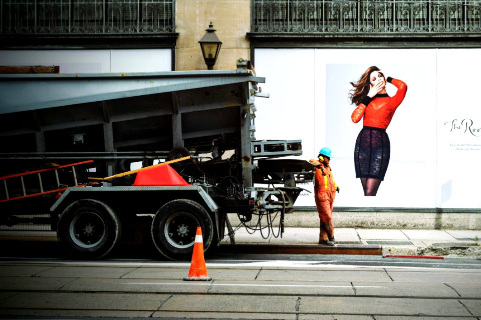Man In Orange Safety Suit Standing Beside Truck Bed