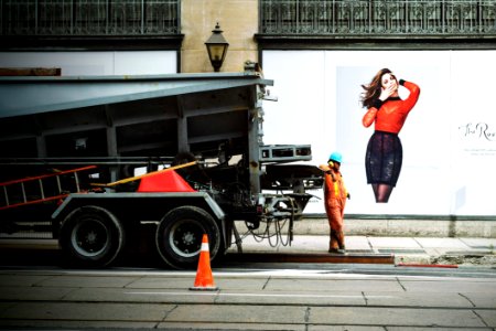 Man In Orange Safety Suit Standing Beside Truck Bed